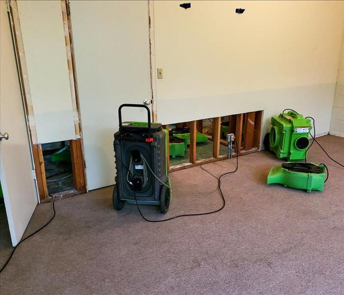 Removed drywall and drying equipment on floor.
