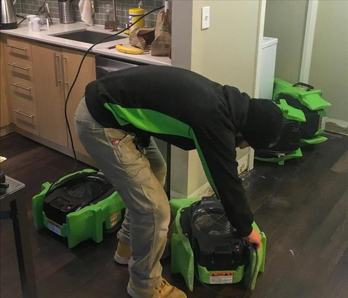 Team member setting up drying equipment.