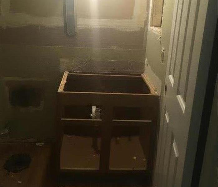Foundation of cabinets sitting on a torn up floor.